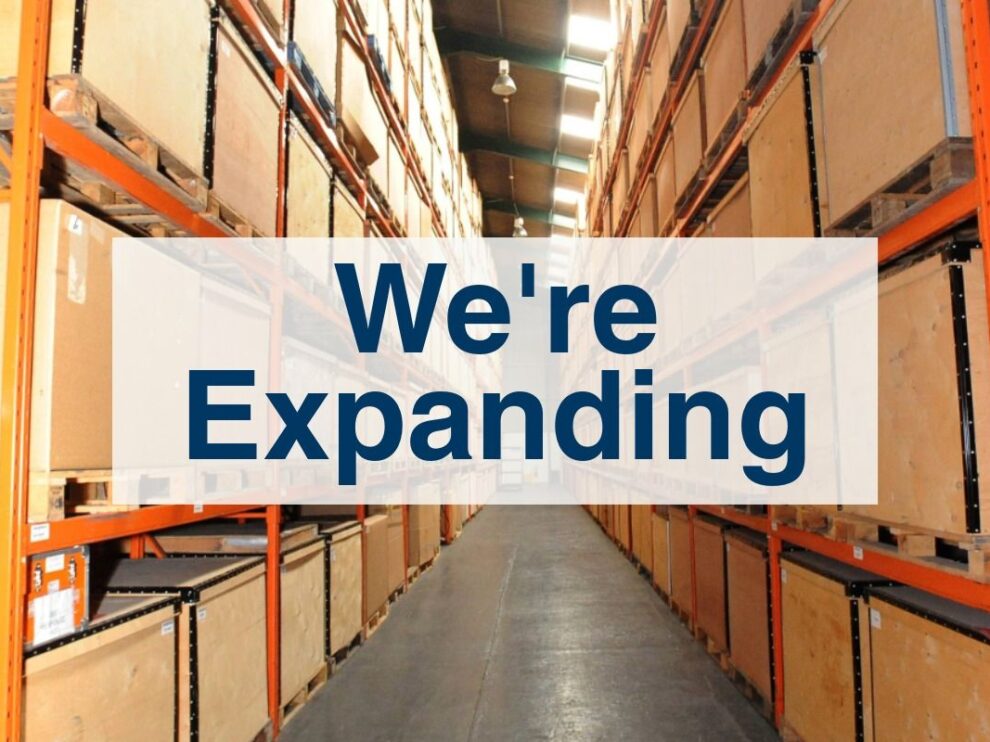PalStore Warehouse aisle of boxes with text "We're Expanding"
